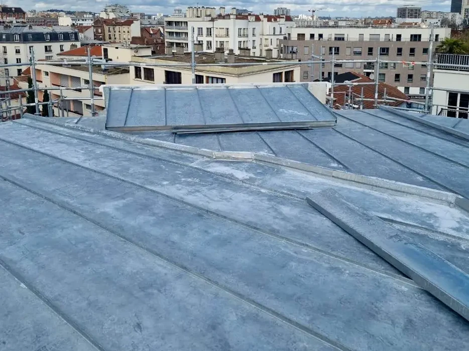 Chantier de construction résidentielle avec installation de gouttières en aluminium blanc