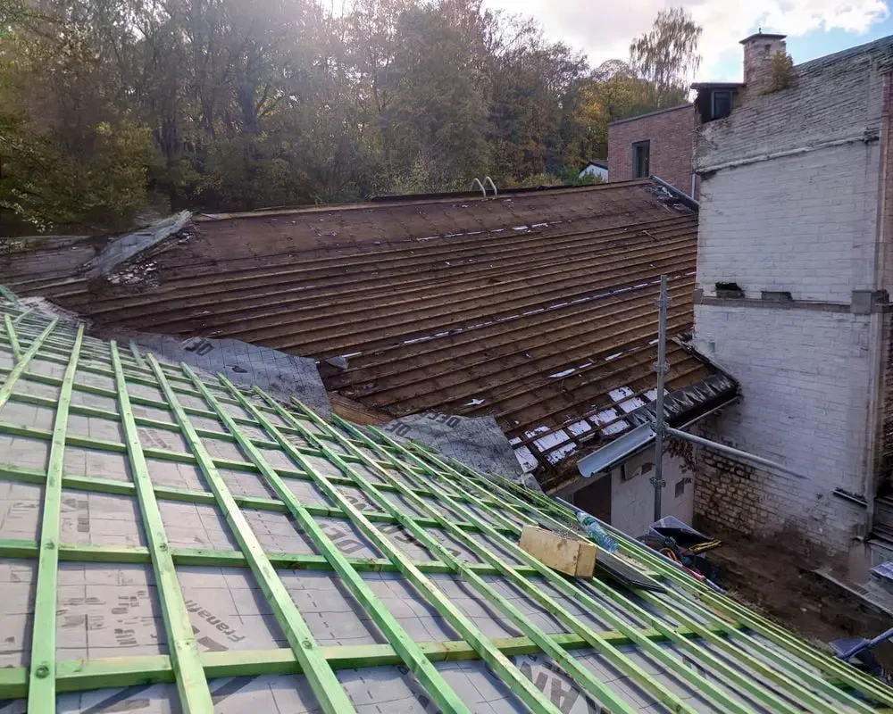 Toiture en tuiles mécaniques rouge-orangé avec quatre fenêtres de toit rectangulaires intégrées