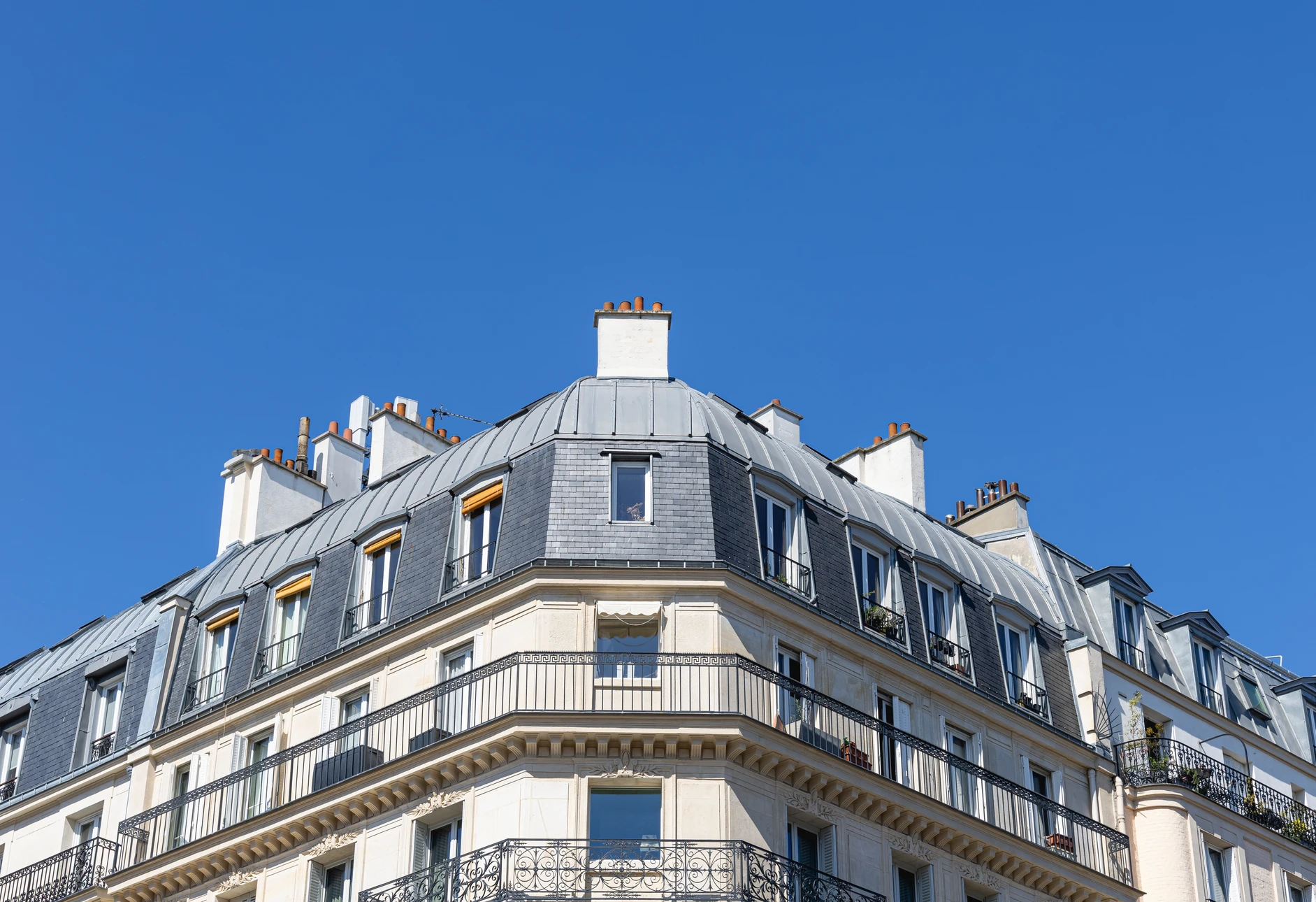 Ouvrier effectuant des travaux de couverture sur toiture en tuiles canal terre cuite