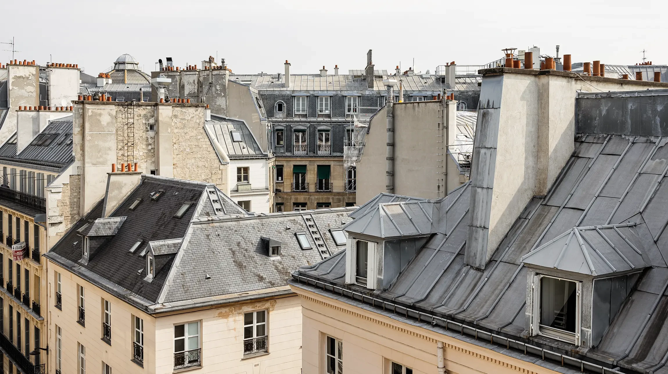Photographie d'un couvreur expérimenté en équipement de sécurité professionnel (harnais, casque) travaillant sur une toiture résidentielle moderne, effectuant une réparation ou installation de tuiles ou de panneaux de couverture. La perspective doit montrer clairement le travail en hauteur avec des outils professionnels de couverture (échelle, charpente visible), capturant l'expertise et la sériosité du métier. Lumière naturelle de jour, qualité professionnelle haute résolution.